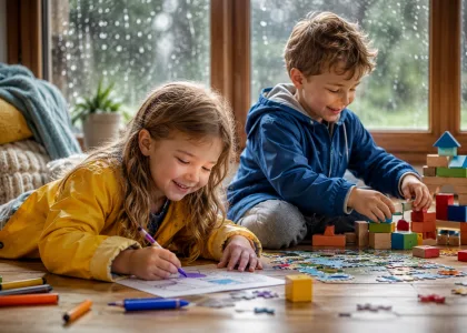 A girl in a raincoat colouring on the floor while a boy builds with wooden blocks.